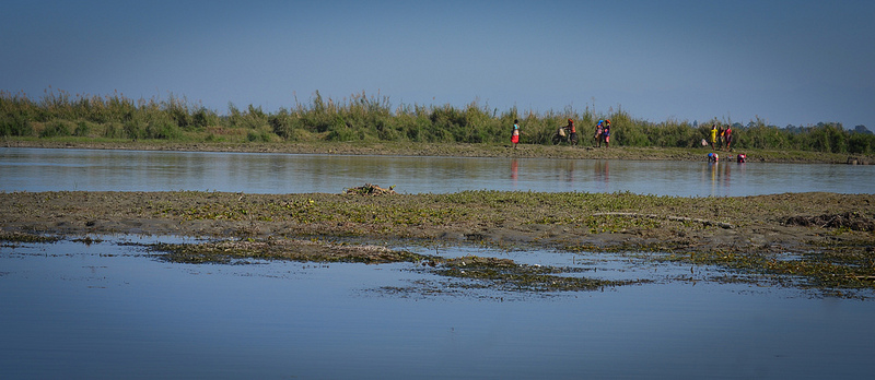 People walking on the other bank of the beel