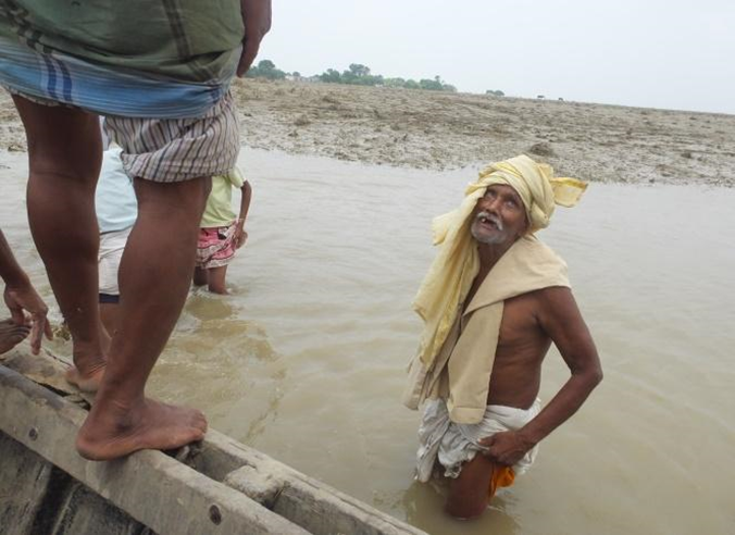 Jab Lal Mehto looks worried about the grasslands that have been destroyed by the floods. People like him from the village Qutubpur on the island on the other side of the bank have to make the treacherous crossing across the Ganges.