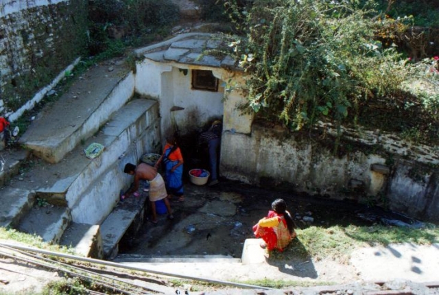 photo of an urban spring with people bathing and washing clothes