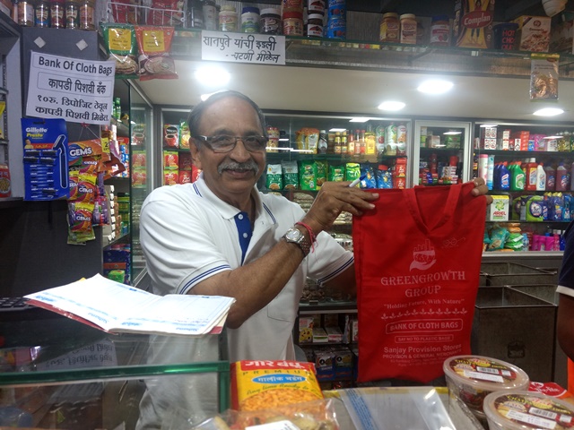 Sanjay shows the cloth bag he provides at his store. (Image Source: India Water Portal)