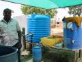 Alagesan with the barrel used to ferment cow dung 