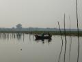 Two men fish from a small rowboat on the placid Ramganga near Harewali