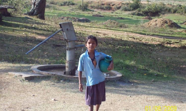 Girl fetching water from handpump (Source: Flickr photos via IWP)