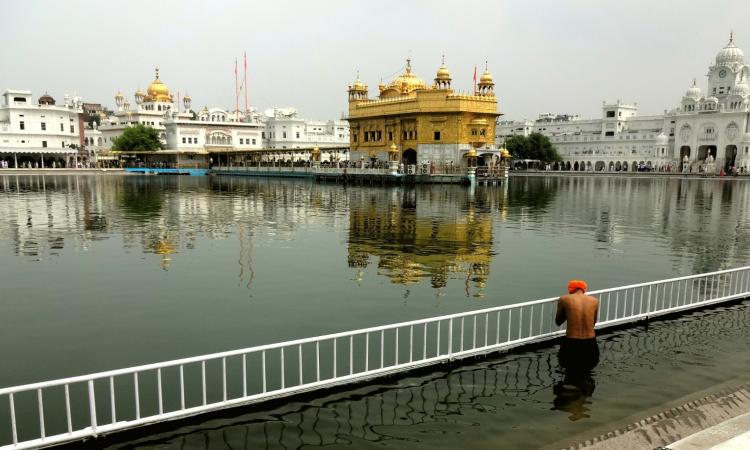 A devotee takes a dip in the holy sarovar