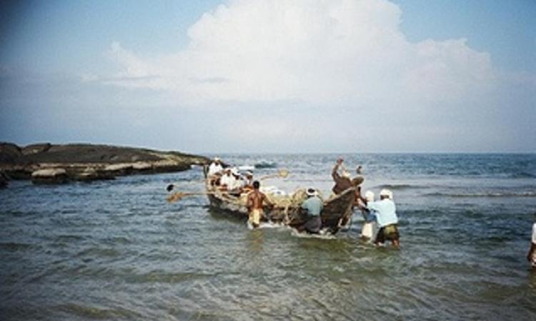 Fishermen launching their boat into the sea