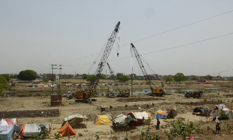 Earth movers cluster on the riverbed of the Gomti, engaged in channelizing the river