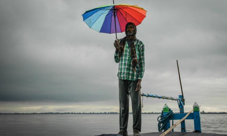 A boatman looks at the vast and furious Brahmaputra